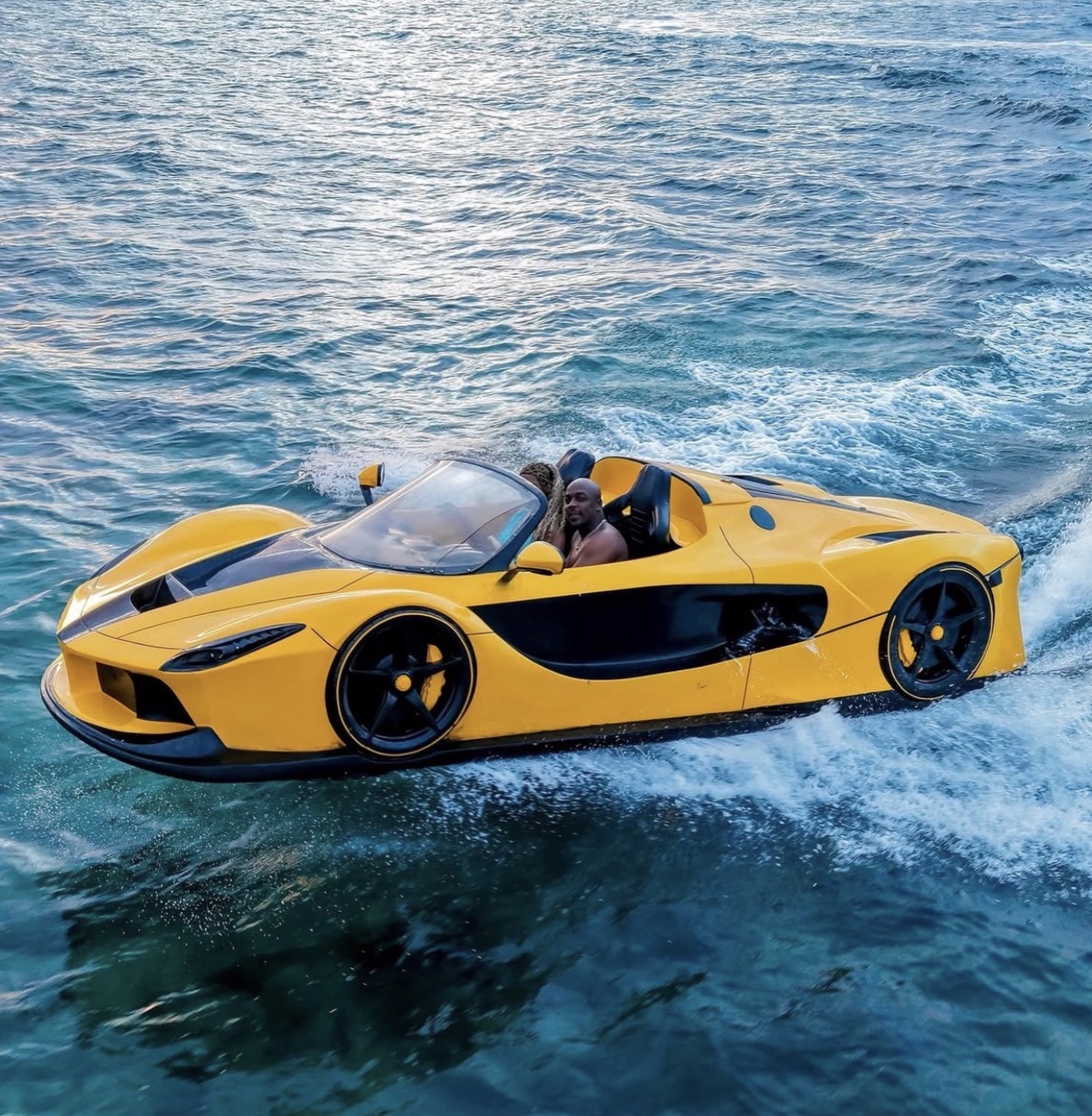 Yellow jetcar at speed with driver and passenger on the water